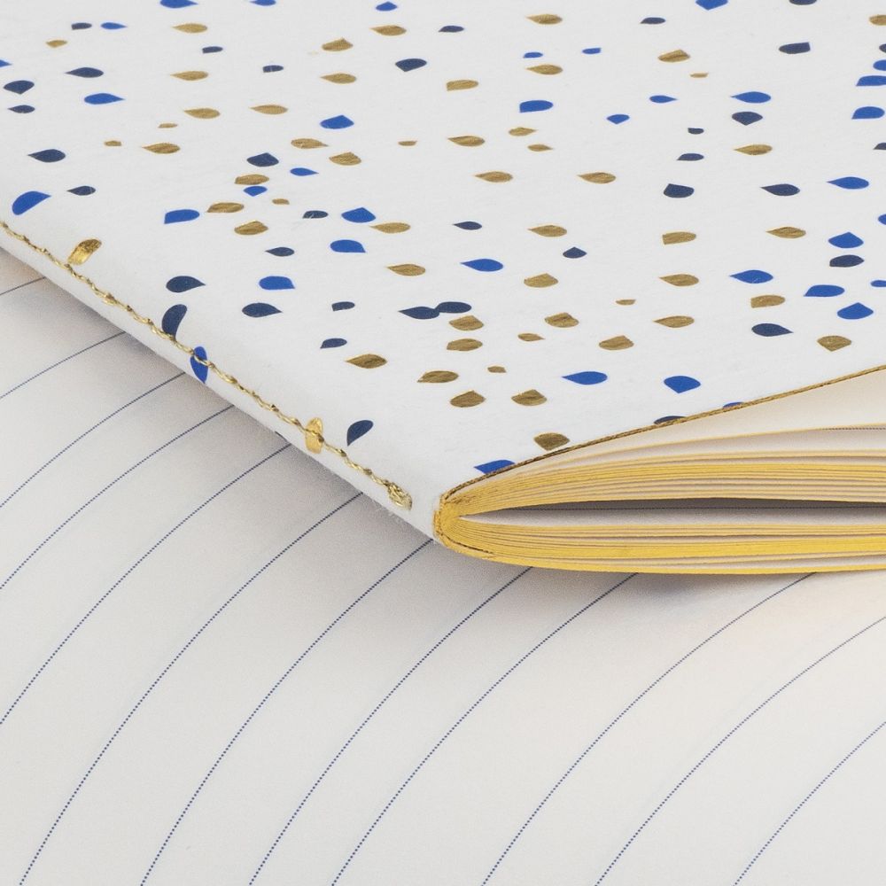 MOGI notebook with golden and blue dots close up.